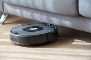 staubsauger-roboter saugt unter einem sofa