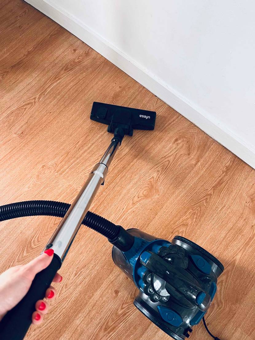 Staubsauger im Test: Gerät steht auf dem Boden. Der Schlauch wird gehalten.