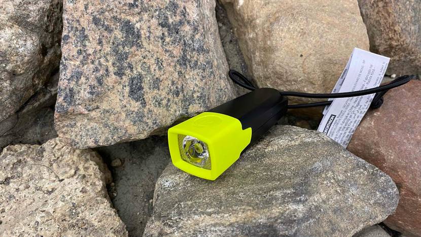 Im Test: Eine Taschenlampe auf und vor mehreren Steinen.