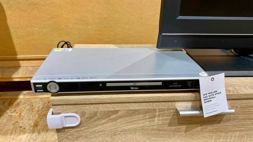 DVD Player getestet: Ein DVD Player auf einer Holzfläche unterhalb eines Monitors.