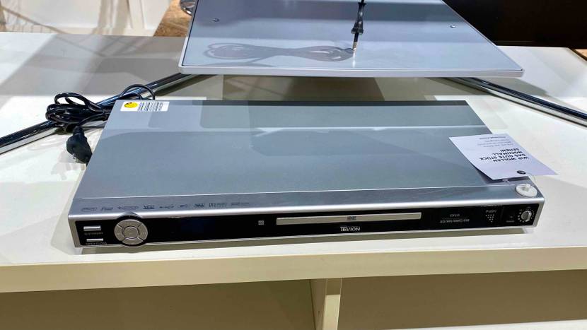 Ein getesteter DVD Player auf einer weißen Fläche inklusive Kabel.