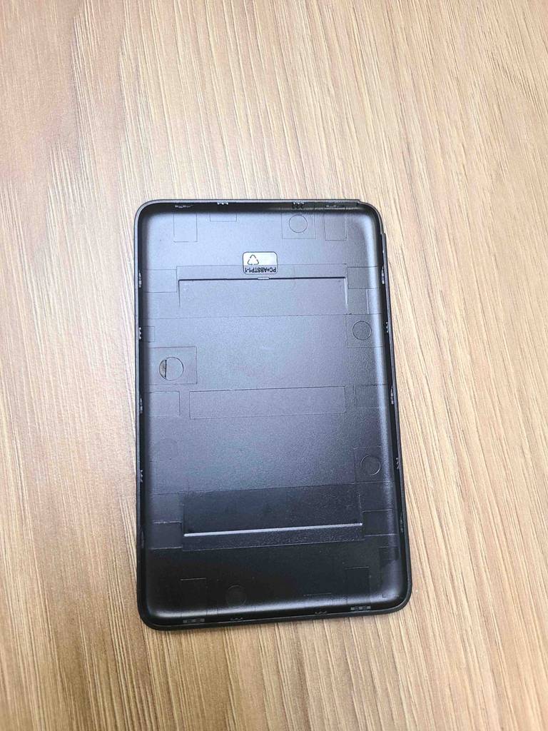 Der schwarze mobile WLAN-Router im Test liegt mit der Rückseite nach oben auf einer Holzoberfläche.
