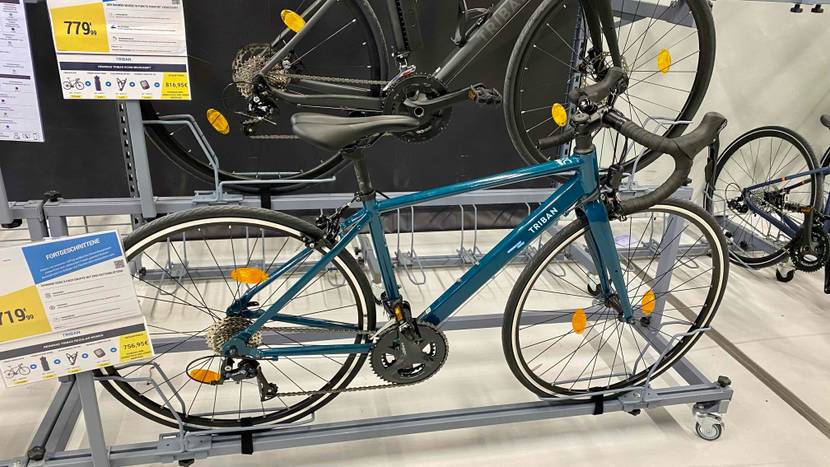 Im Test: Ein Rennrad von der Seite in einer Halterung mit Preisangaben.