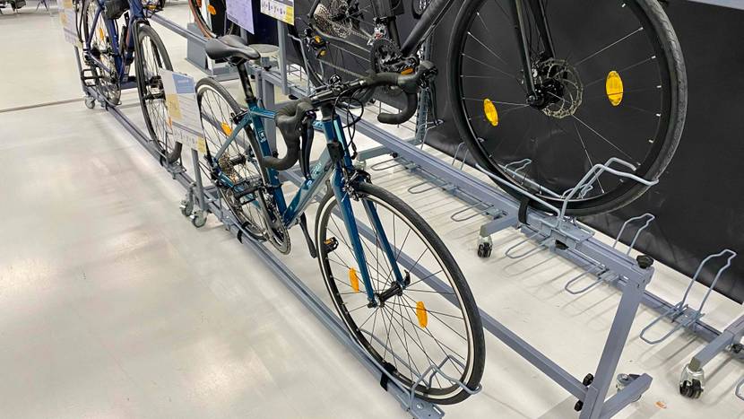 Ein getestetes Rennrad von schräg vorne in einer Halterung neben anderen Produkten.
