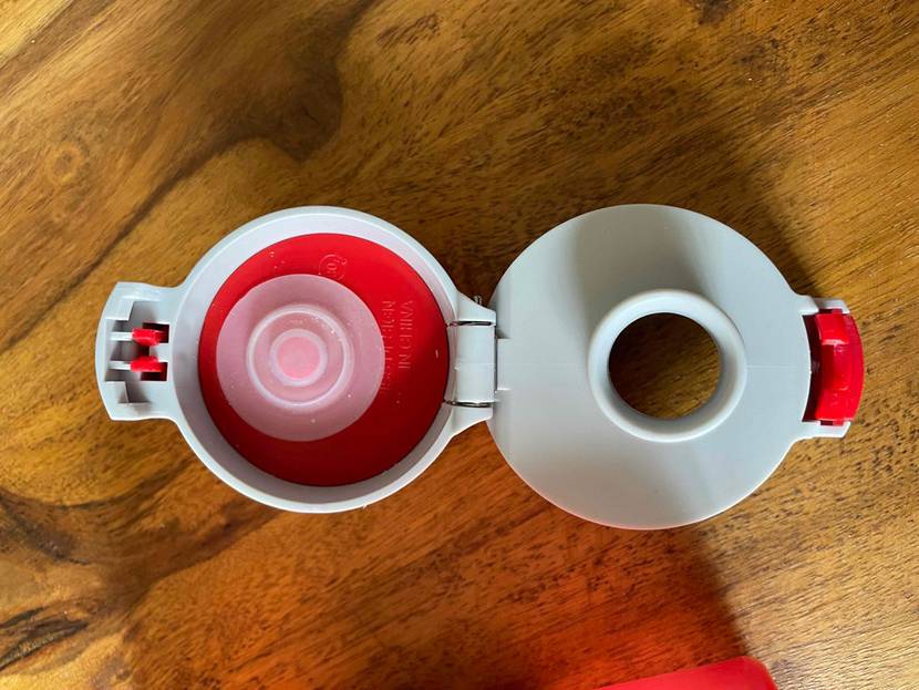 Trinkflasche-Kind im Test: TRinkflöasche von oben fotografiert mit geöffnetem Deckel auf Holzboden stehend.